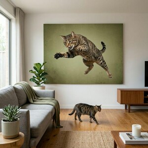 May include: A large rectangular wall art print featuring a brown tabby cat captured in mid-air while jumping. The cat has dark stripes, a focused expression, and is positioned against a solid, muted olive green background with a subtle texture.
