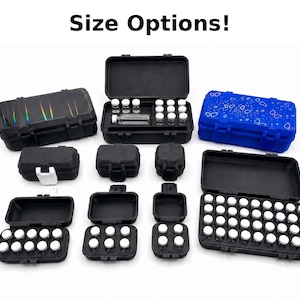 May include: An assortment of black, blue, and iridescent storage cases, some open to reveal small glass vials with white caps. The cases vary in size and shape, with the text "Size Options!" at the top.