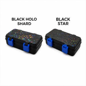 May include: Two black rectangular storage boxes with blue clasps. One box is labeled "BLACK HOLO SHARD" and has a holographic shard pattern. The other box is labeled "BLACK STAR" and has a star pattern.