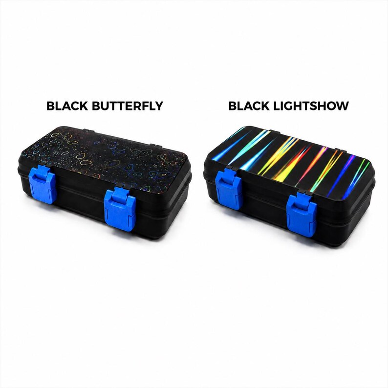 May include: Two black rectangular storage boxes with blue clasps. One box is decorated with a butterfly pattern, and the other with a light show design. The text "BLACK BUTTERFLY" and "BLACK LIGHTSHOW" are above each box.