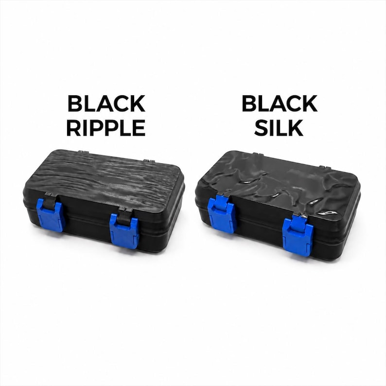 May include: Two black rectangular boxes with blue clasps. The box on the left has a ripple texture, and the box on the right has a silk texture. The text "BLACK RIPPLE" and "BLACK SILK" are above the boxes.