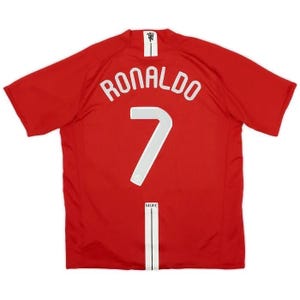 Könnte beinhalten: Ein rotes Fußballtrikot mit dem Namen "RONALDO" und der Nummer "7" in Weiß auf dem Rücken. Das Trikot hat einen weißen Kragen und einen vertikalen weißen Streifen mit den Buchstaben "MUFC" unten.