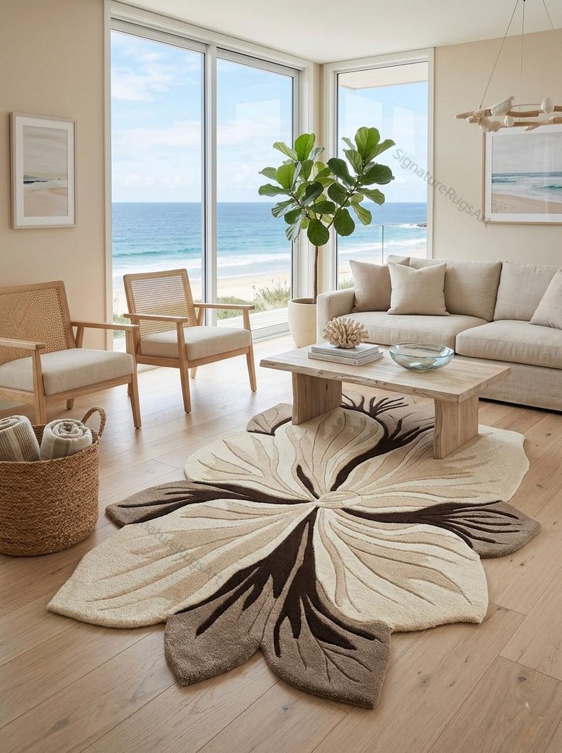 May include: An area rug featuring a large, organic, flower-like shape with layered petals in shades of cream, beige, and dark brown. The rug has a textured, tufted surface with carved details that define the petal edges and central core.