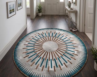 May include: A round rug with a sunburst design in a hallway. The rug features a gray center, with brown and teal rectangular accents radiating outwards. The border is teal with white triangular shapes. The rug is on a dark wood floor.