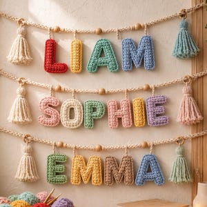Può includere: Striscioni con nomi all'uncinetto che compongono "LIAM", "SOPHIE" e "EMMA" in lettere colorate. Ogni nome è sospeso a una corda con perline di legno e nappe decorative. Le lettere sono rosse, gialle, verdi, blu, rosa e marroni.