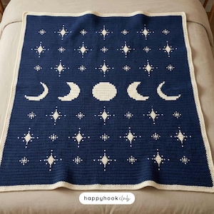 Könnte beinhalten: Eine marineblaue Häkeldecke mit cremefarbenem Rand. Die Decke hat ein sich wiederholendes Muster aus weißen Sternen, Halbmonden und einem Vollmond. Die Decke ist quadratisch und scheint handgefertigt zu sein.
