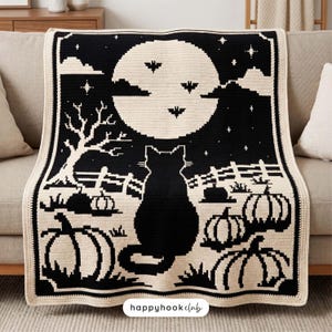 May include: A black and cream crochet blanket featuring a large full moon, a silhouette of a cat, pumpkins, a bare tree, and bats. The text "happyhookclub" is printed in a white oval at the bottom center of the rectangular textile piece.