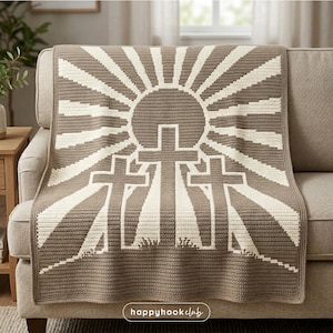 May include: A crocheted blanket featuring a design of three crosses beneath a sunburst. The blanket is primarily brown with cream-colored accents. The text "happyhook club" is in the lower right corner.