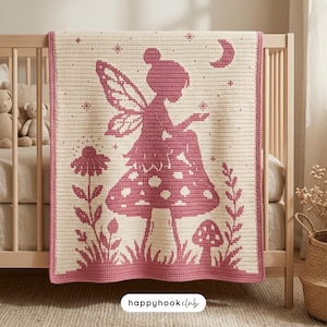 May include: A rectangular crochet blanket featuring a cream-colored base with a dark pink design of a fairy sitting on a large mushroom. The pattern includes a crescent moon, stars, and floral elements. The text happyhookclub is visible below.