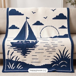 May include: A rectangular crochet blanket featuring a dark blue and cream nautical scene. The design depicts a sailboat on water, a large sun, clouds, and birds. The text "happyhookclub" is printed in a white oval at the bottom centre.