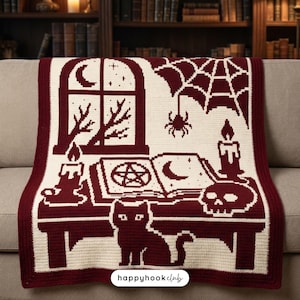 May include: A maroon and cream crochet blanket featuring a pixelated design of a window with a crescent moon, a spider web with a spider, two lit candles, an open book with a pentagram and moon symbol, a skull, and a cat sitting at the base.