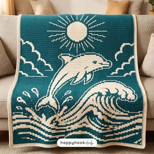 May include: A teal and cream crochet blanket featuring a pixelated design of a dolphin leaping from ocean waves toward a sun in the sky. The blanket has a cream-colored border and includes the text "happyhookclub" at the bottom center.