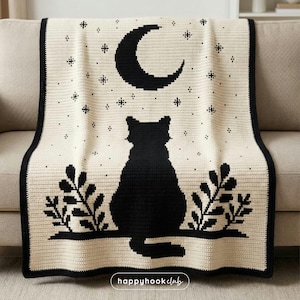 May include: A cream-colored crochet blanket featuring a black cat silhouette, a crescent moon, and stars. The blanket has a black border and is draped over a beige sofa. The words "happyhookclub" are in the bottom right corner.