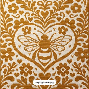 May include: A mustard yellow and off-white crocheted textile featuring a central bee motif enclosed within a heart shape, surrounded by symmetrical floral and leaf patterns. The bottom center includes a white label with the text happyhookclub.