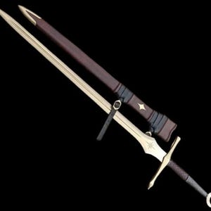 May include: A double-edged steel sword with a gold-toned crossguard and pommel, featuring a star emblem on the blade. The sword is accompanied by a dark brown leather scabbard with black leather straps and a matching star-shaped metal inlay.