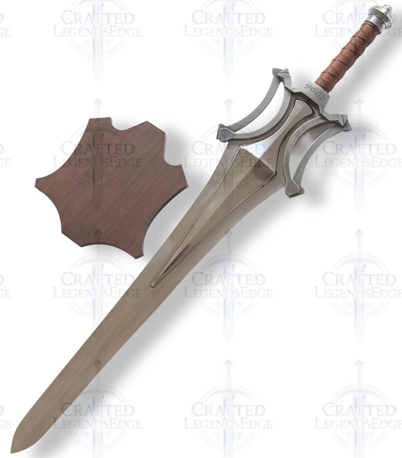 May include: A silver-colored sword with a brown leather-wrapped handle and a matching wooden shield. The sword has a long, double-edged blade and ornate crossguard. The shield is a dark brown, irregular shape.
