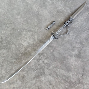 May include: A silver-colored sword with an ornate handle and a separate, smaller piece. The blade is long and straight, with etched designs. The handle features intricate detailing, and a curved guard. The smaller piece has a twisted design.