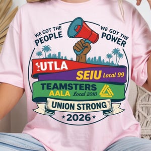 Labor movement PNG union strong workers rights protest design featuring a raised fist holding a red megaphone above a city skyline with palm trees, layered banners displaying UTLA SEIU Teamsters AALA and “Union Strong 2026” text, bold modern activist style with vibrant red, teal, green, and yellow colors, ideal for shirt sublimation, protest apparel, and digital download PNG file for union supporters and activists