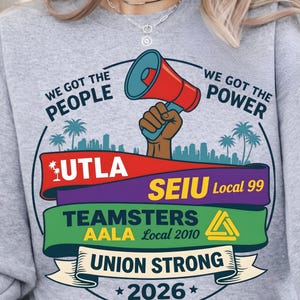 Labor movement PNG union strong workers rights protest design featuring a raised fist holding a red megaphone above a city skyline with palm trees, layered banners displaying UTLA SEIU Teamsters AALA and “Union Strong 2026” text, bold modern activist style with vibrant red, teal, green, and yellow colors, ideal for shirt sublimation, protest apparel, and digital download PNG file for union supporters and activists