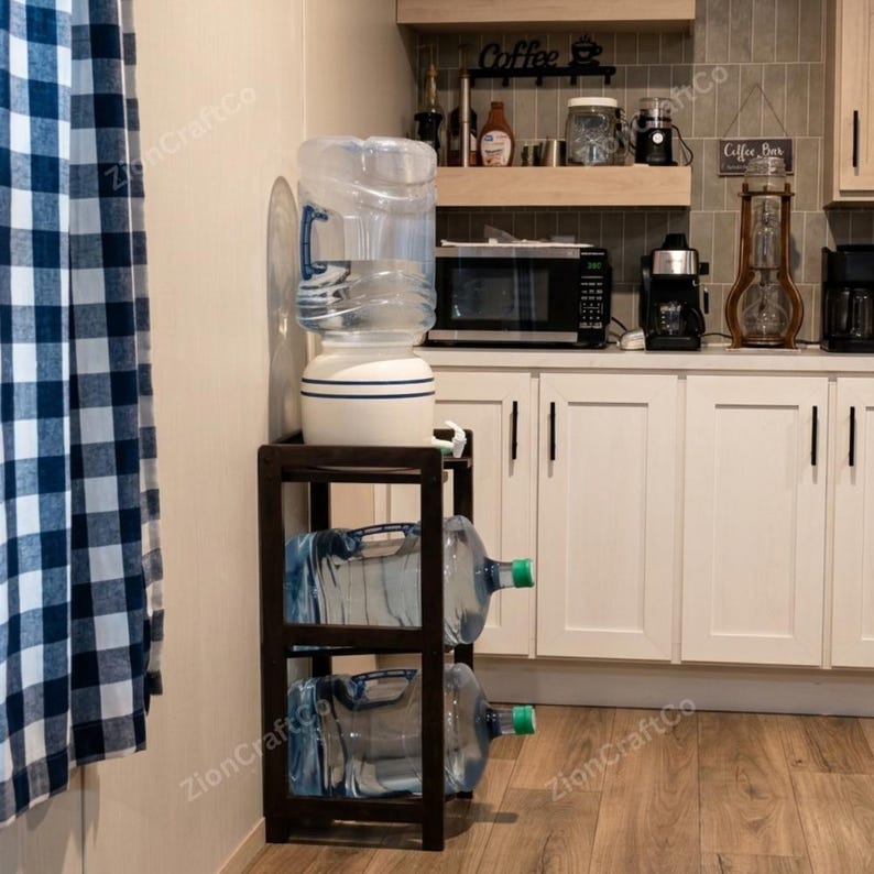 May include: A dark brown wooden water jug storage rack with three tiers. The top tier holds a white ceramic water dispenser base with a large clear plastic water jug. The middle and bottom tiers each hold a clear plastic water jug with a green cap.