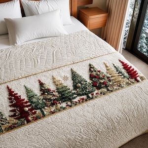 May include: A cream-colored quilted bedspread featuring a horizontal band decorated with embroidered and textured Christmas trees in shades of red, green, and gold, accented with small round ornaments and snowflake motifs.