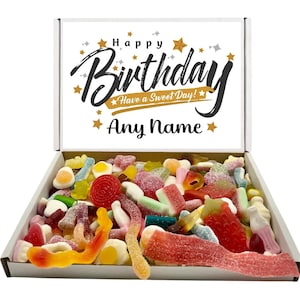 May include: A white cardboard box filled with a variety of colourful gummy sweets. The inside lid features the text Happy Birthday, Have a Sweet Day!, and Any Name in black and gold lettering, surrounded by small gold star graphics.
