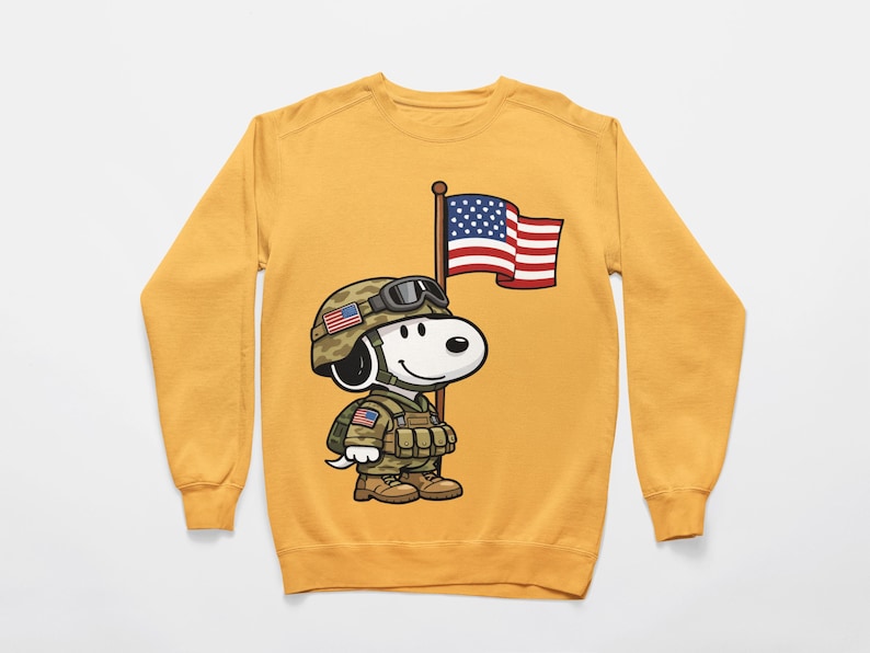May include: Mustard yellow sweatshirt featuring a cartoon Snoopy character dressed as a soldier, complete with a helmet, military uniform, and holding a US flag. The design is a patriotic tribute, perfect for casual wear.