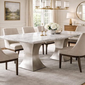May include: A dining room set featuring a marble-topped table with a unique pedestal base and six upholstered chairs. The chairs have dark wooden legs and a light beige fabric. A gold chandelier hangs above the table.