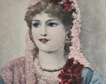 Postal antigua de principios del siglo XX: Retrato de mujer victoriana con chal rosa y flores. Matasellos de 1909.