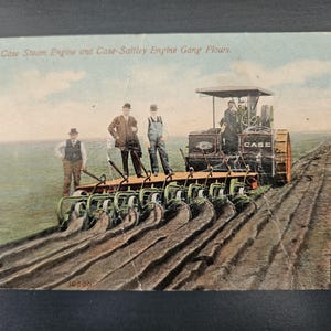 May include: A white ceramic mug with a black handle and the text "But First, Coffee" in a bold, black font. The mug is sitting on a wooden surface. The mug is approximately 4 inches tall.