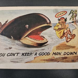 May include: Vintage postcard illustration depicting a large whale with an open mouth and a man labeled "Jonah" on the shore. The text "You can't keep a good man down" is at the bottom.