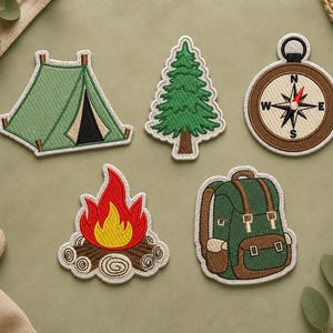 May include: Embroidered patches with camping and outdoor themes. Designs include a green tent, a pine tree, a compass, a campfire, and a backpack. Each patch has a white border and detailed stitching.