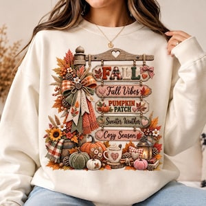 Puede incluir: Una sudadera de cuello redondo color crema con un estampado gráfico de un letrero de madera con el texto FALL, Fall Vibes, PUMPKIN PATCH, Sweater Weather y Cozy Season, rodeado de calabazas, hojas de otoño, una taza y una linterna.