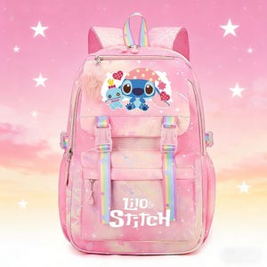 May include: Pink backpack featuring a cartoon image of Stitch and the words "Lilo & Stitch". The backpack has rainbow-colored straps and a fluffy pink pom-pom. It has multiple compartments and adjustable straps.