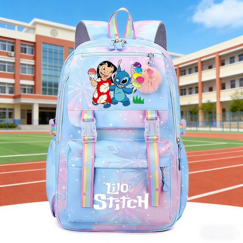 May include: A light blue backpack featuring the characters Lilo and Stitch. The backpack has a front flap with a zipper pocket, rainbow straps, and a fluffy pink keychain. The text "Lilo & Stitch" is printed on the front.