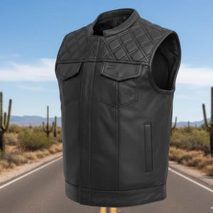 May include: Black leather vest featuring a quilted shoulder design and two front pockets. The vest has a classic biker style with a round collar and a vertical pocket on the lower left side. The vest is sleeveless and appears to be made of genuine leather.