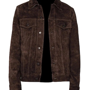 May include: A brown suede jacket with a classic design. The jacket features a collared neckline, two chest pockets with button closures, and buttoned cuffs. The jacket is buttoned down the front.