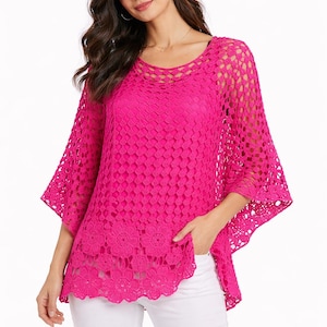 May include: A bright pink crochet top with a round neckline and three-quarter sleeves. The top features a floral pattern along the bottom hem and a loose, flowing fit. The model is wearing white pants.