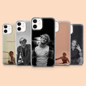 Puede incluir: Una taza de cerámica blanca con un asa negra y el texto "But First, Coffee" en negro y negrita. La taza está sobre una superficie de madera. La taza mide 10 cm de alto.