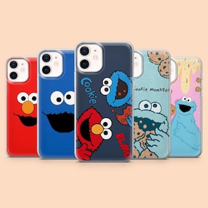 May include: A collection of five phone cases featuring Sesame Street characters. The cases showcase Elmo, Cookie Monster, and other characters in vibrant colors. The cases have a clear protective design.