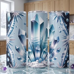 May include: Three stainless steel tumblers with a crystal design. The tumblers have a light blue background with illustrations of blue and white crystals. The design wraps around the entire tumbler. Each tumbler is approximately 20 cm tall.
