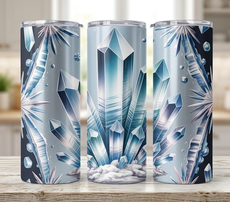 May include: Three stainless steel tumblers with a wraparound design of blue and white crystals. The design features geometric crystal formations and a snowy base, set against a gradient background. Each tumbler is approximately 20 cm tall.