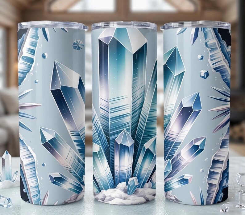 May include: Three stainless steel tumblers with a wraparound design of blue and white crystals. The design features geometric crystal formations on a light blue background, creating a cool, icy aesthetic.