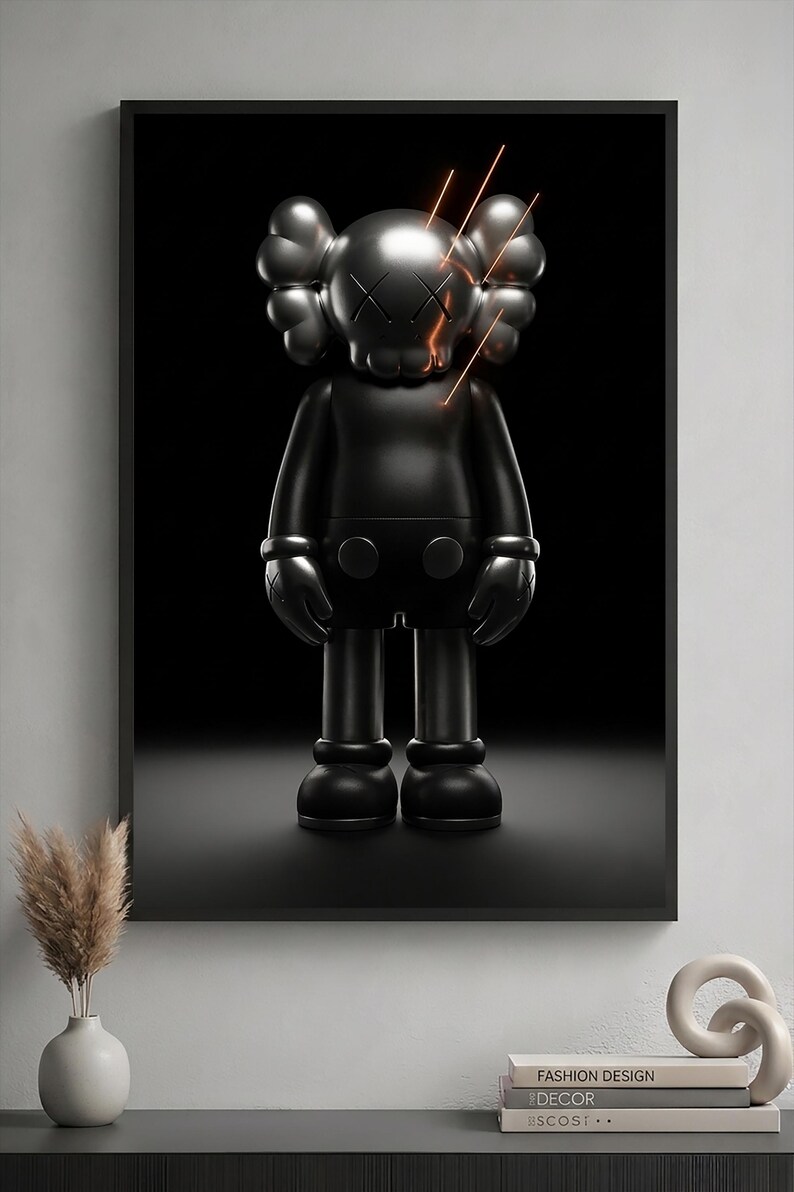 May include: A framed wall art print featuring a matte black KAWS-style character figure with X-shaped eyes and glowing orange light streaks emanating from the head, set against a solid black background within a thin black frame.