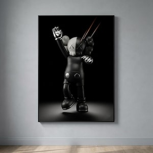 May include: A framed wall art print featuring a black and white KAWS character figure with X-shaped eyes. The figure is depicted in a dynamic pose with one arm raised, set against a solid black background with two thin red light streaks above.