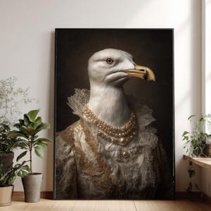Könnte beinhalten: Ein gerahmter Porträtdruck einer weißen Möwe mit gelbem Schnabel, die eine mehrreihige Perlenkette und ein hochgeschlossenes, aufwendiges Kleidungsstück aus goldener und cremefarbener Spitze vor einem dunklen Hintergrund trägt.