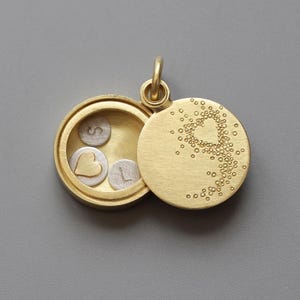 small golden living locket with heart on the lid filled with initials and golden heart