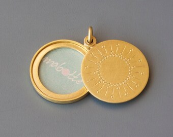 round golden picture-locket with sun design