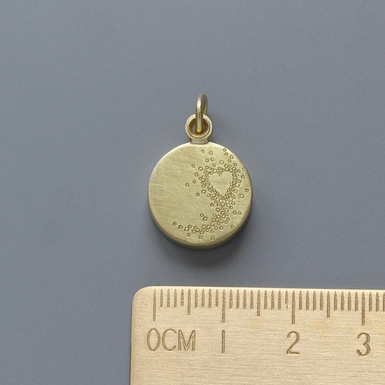 Pu&ograve; includere: Ciondolo pendente color oro con un design circolare. Il ciondolo presenta una forma di cuore fatta di piccoli punti.