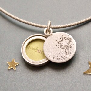 small silver picture locket with a shooting star